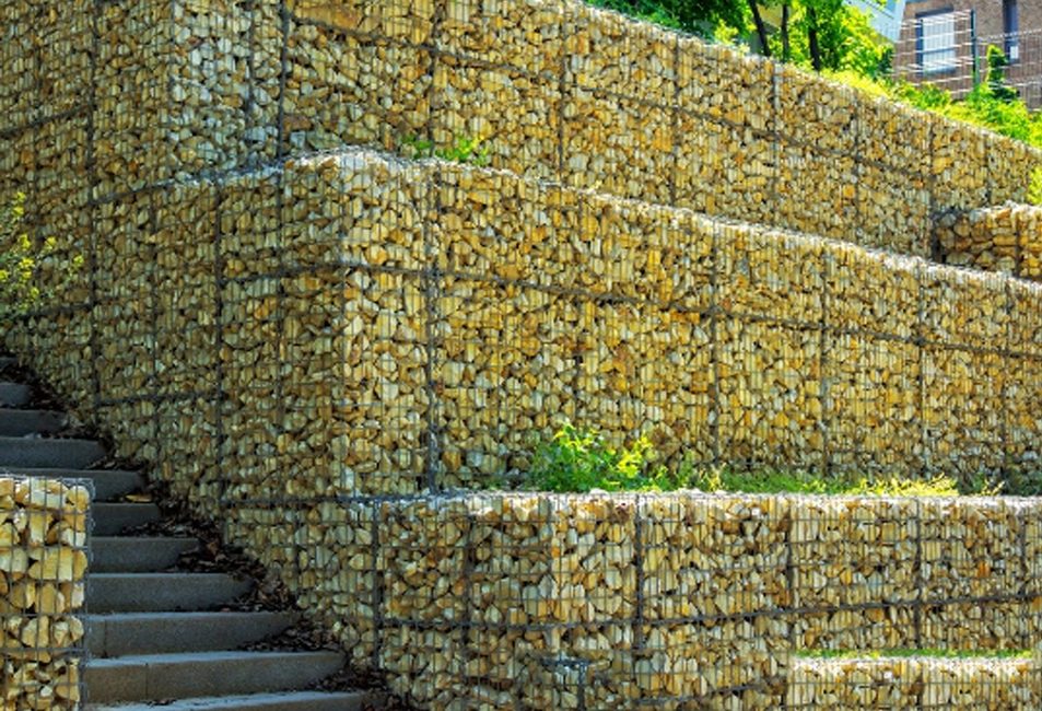Retaining Walls Sydney: Stone retaining wall with stairs and landscaping, showcasing professional installation.