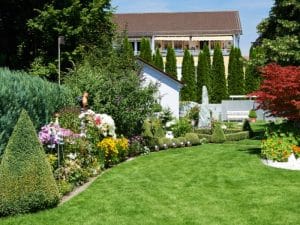 A green lawn and flower beds show designing your garden creatively.